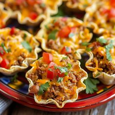 several taco cups on a red plate with toppings and garnishes