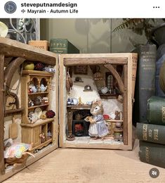 an open book with miniature mouse figurines in it on a table next to books