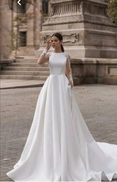 a woman in a white wedding dress standing outside