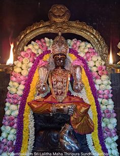 the statue is surrounded by flowers and candles