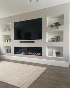 a large flat screen tv mounted on the wall above a fireplace in a living room