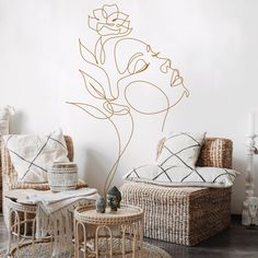 a living room with wicker furniture and a flower wall decal on the wall