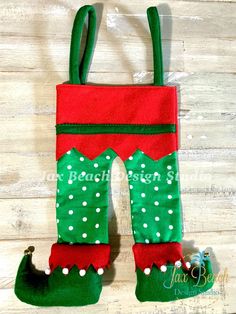 a green and red christmas stocking hanging on a wooden wall