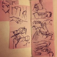 an open book with drawings of people and hands on pink paper in front of them