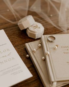 wedding rings and ring box on the table next to an open book that says color innor