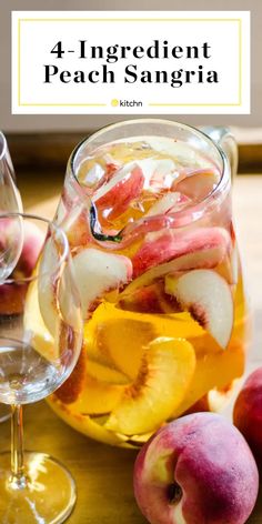 a pitcher filled with sliced peaches next to two glasses of wine and some fruit