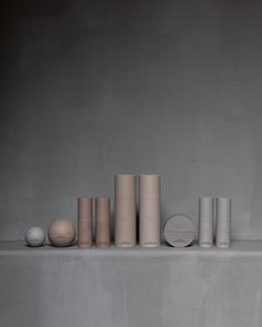 there are many different shapes and sizes of vases on the shelf in front of each other