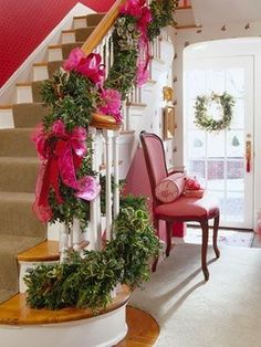 a staircase decorated with pink flowers and greenery next to a red chair in front of the stairs