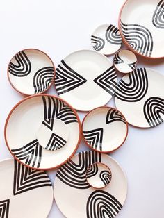 several black and white plates stacked on top of each other with geometric designs in them