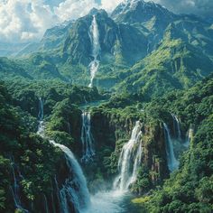 an aerial view of a waterfall surrounded by green trees and mountains with clouds in the sky