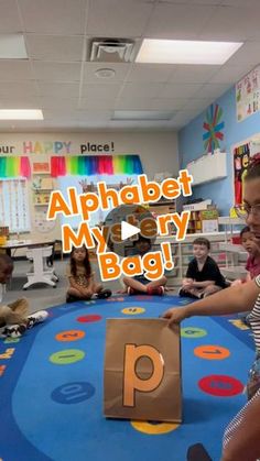 children sitting around a play area with an alphabet sign on the floor in front of them