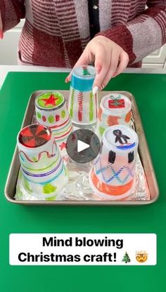 a woman is decorating christmas cupcakes on a tray with the words, mind blowing christmas craft