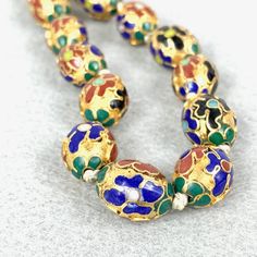 Gorgeous Chinese export floral enamel champleve gold gilt oval  beads with a gold washed silver filigree clasp.The beads are decorated with royal blue, green and carnelian flowers with vari-color centers. Each bead measures 16 mm. Clasp is tarnished, but beads are in excellent shape. These are very high quality and a rarer design. These will garner compliments every time you wear them. Please visit all six RareBeauty shops on Etsy! Bohemian Gold Enamel Necklace, Gold Bohemian Enamel Necklace, Gold Enamel Bohemian Necklace, Ornate Round Beads For Jewelry Making, Traditional Enamel Necklaces For Formal Occasions, Gold Jewelry With Colorful Oval Beads, Traditional Gold Enamel Necklaces, Vintage Meenakari Gold Necklace, Vintage Gold Meenakari Necklace