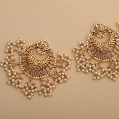 Description: Grab these alluring and exquisite handcrafted chandbali earrings from Tarinika. This set of antique gold-toned traditional chandbali earrings is suitable for all occasions. Studded with dazzling CZ stones and cluster pearl drops, it symbolizes royal elegance. Add this must-have accessory to your collection to pair with ethnic Anarkali's or with a traditional silk saree. Details & Specifications: Materials used: Brass Alloy with Antique Plating Weight – 43 gm Length – 7 cm Make it cu Chandbali Bridal Earrings With Intricate Design For Eid, Eid Chandbali Bridal Earrings With Intricate Design, Eid Bridal Chandbali Earrings With Intricate Design, Bollywood Style Chandbalis With Intricate Design For Eid, Eid Kundan Chandbalis With Intricate Design, Chandbalis With Stone Work For Navratri, Stone Work Chandbalis For Navratri, Eid Chandbalis With Intricate Kundan Design, Navratri Chandbalis With Stone Work