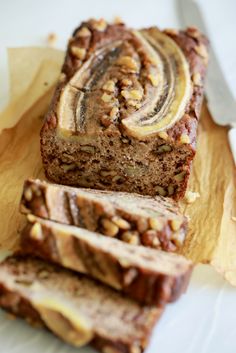 sliced loaf of banana bread sitting on top of a wooden cutting board