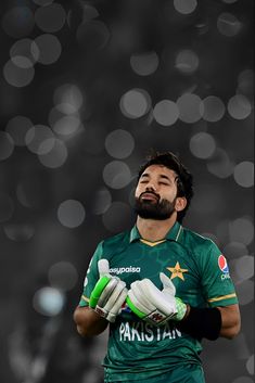 a man with a beard and green uniform holding his hands together in front of him