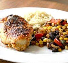 a white plate topped with chicken, beans and mashed potatoes