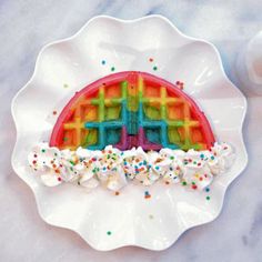 a waffle cake decorated with sprinkles on a plate next to a glass of milk