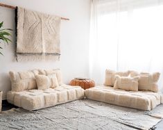 a living room filled with furniture and a rug on top of a floor next to a window