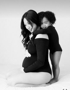 a black and white photo of a woman holding a baby