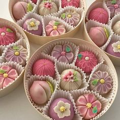 four bowls filled with pink and white chocolates on top of a table next to each other