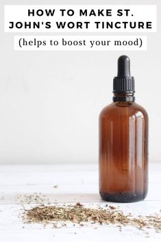 a bottle filled with brown liquid sitting on top of a white table next to a pile of herbs