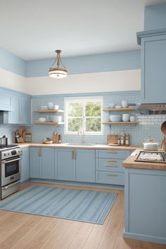 a kitchen with light blue cabinets and wood flooring is pictured in this image, there is a rug on the floor next to the stove