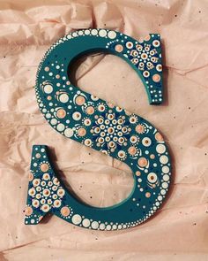 the letter s is decorated with flowers and dots