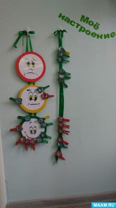 there are many magnets on the wall that have faces and hairbrushes attached to them