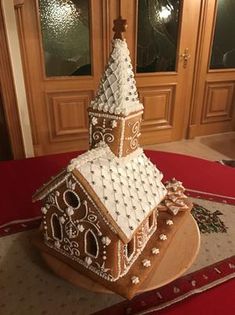 a large gingerbread house is on display in front of a door and red carpet