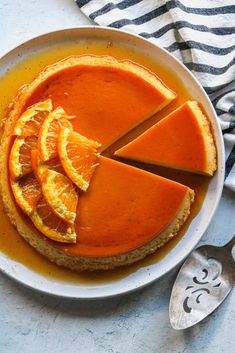 an orange cheesecake on a plate with slices cut out and ready to be eaten