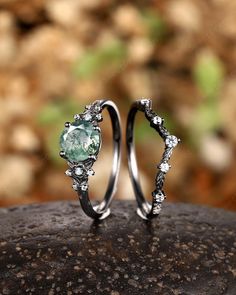 two wedding rings with an aqua green stone in the middle and white diamonds on each side