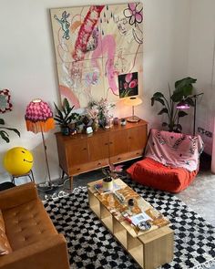 a living room filled with lots of furniture and decor on top of a black and white checkered floor