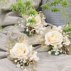 three bridal bouquets with white flowers and greenery on a gray fabric background