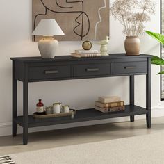 a black console table with two drawers and a lamp next to it in a living room