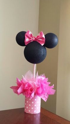 a minnie mouse cake topper with pink and white polka dots in a cupcake holder