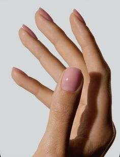 a woman's hand with pink nail polish on it