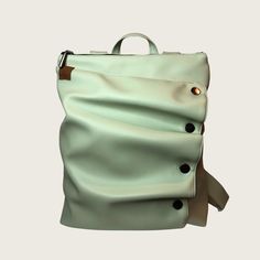 a green leather backpack with buttons on the side