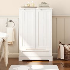 a white cabinet sitting on top of a hard wood floor next to a bath tub