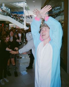 a man is holding his arms up in the air while people look on at him