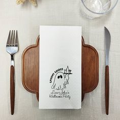 a napkin with a ghost on it sitting next to a knife and fork, along with two forks