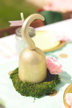 a table topped with a vase filled with moss and a candle holder on top of it