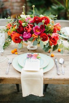 the table is set with flowers and place settings