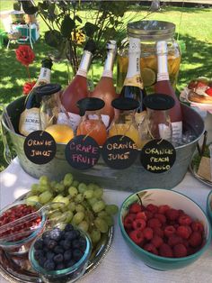 an assortment of fruits and drinks on a table with labels that say grape juice, orange juice, cranberry juice, lemonade punch, and more