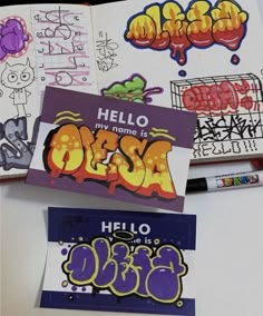 some graffiti stickers are laying on top of a white table with markers and pens