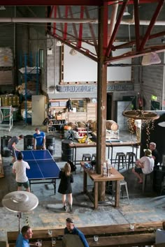 people are playing ping pong in an industrial building