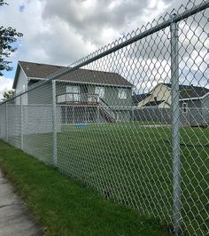 a chain link fence is in front of a house