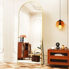 a large mirror sitting on top of a wooden table next to a dresser and lamp