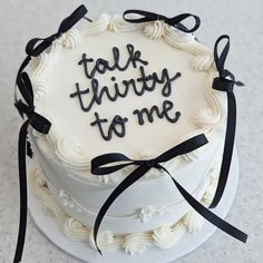 a white cake with black ribbon and the words talk thirty to me on it