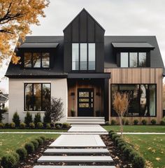 a modern house with black and white trim on the front door, windows, and steps leading up to it